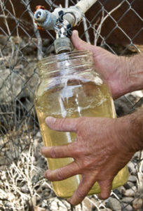 Close up hand holding bottle being filled